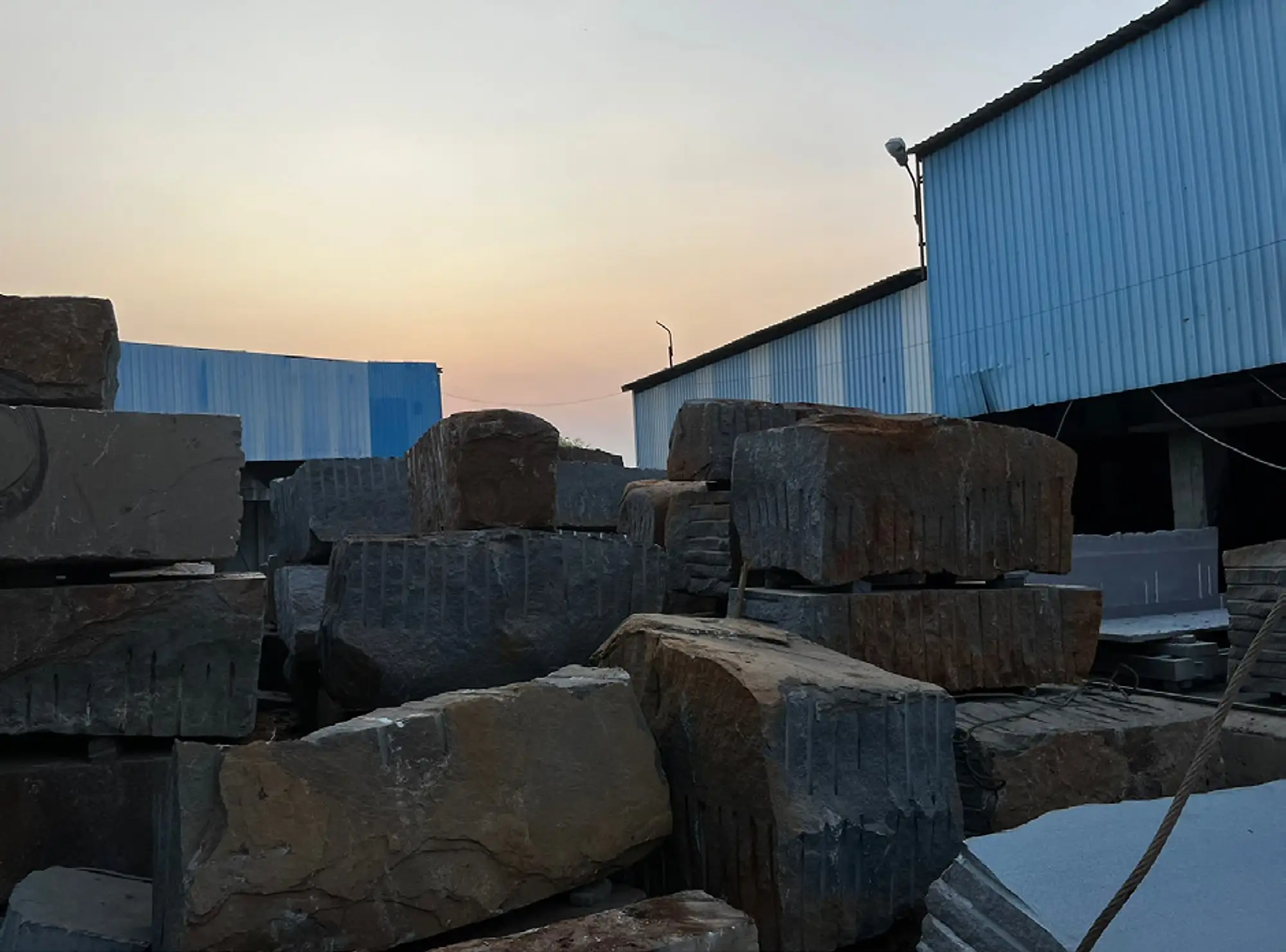 Yard of rough granite blocks at dusk
