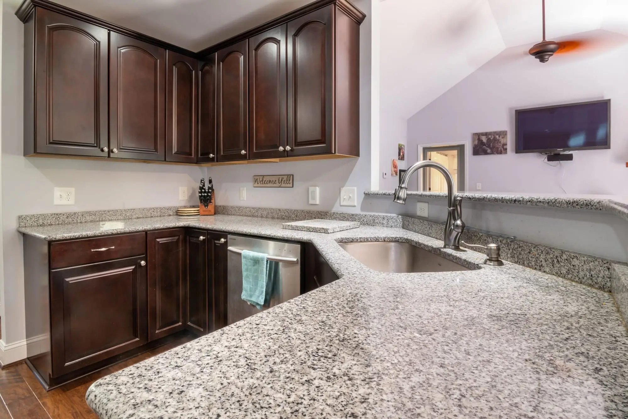 Kitchen with speckled granite countertops and dark wood cabinets