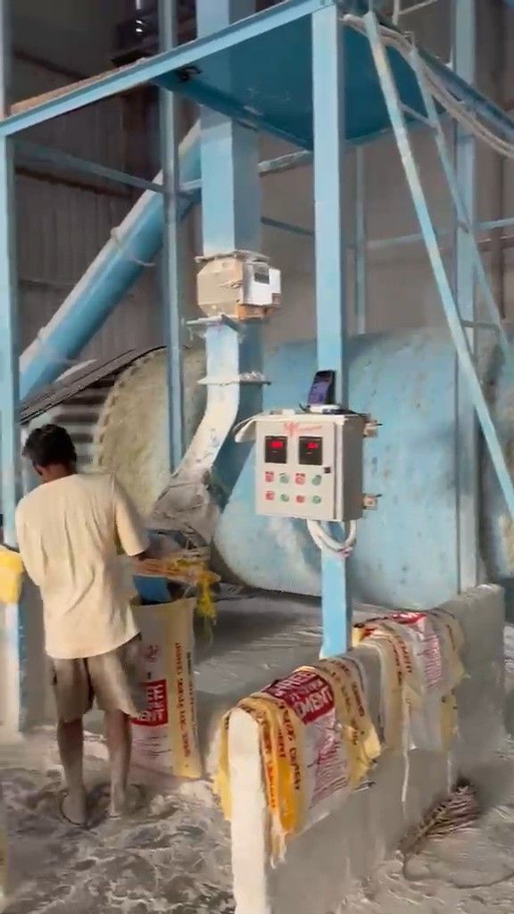 Worker filling bags of powder at the mill