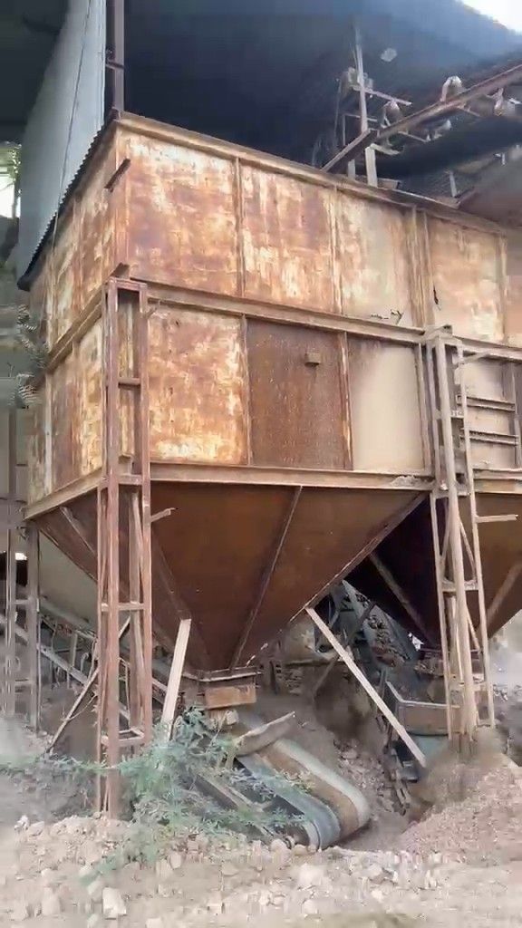 Steel storage hoppers above the conveyor line