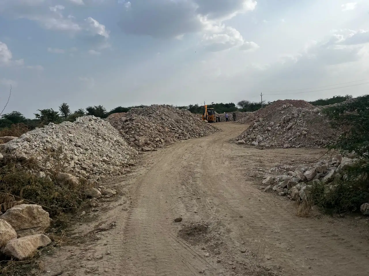 Stockpiles of raw mineral along the plant road