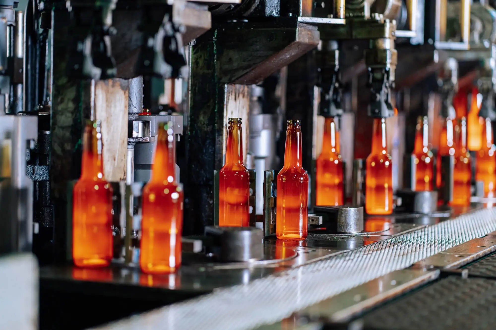 Glowing glass bottles on a production line