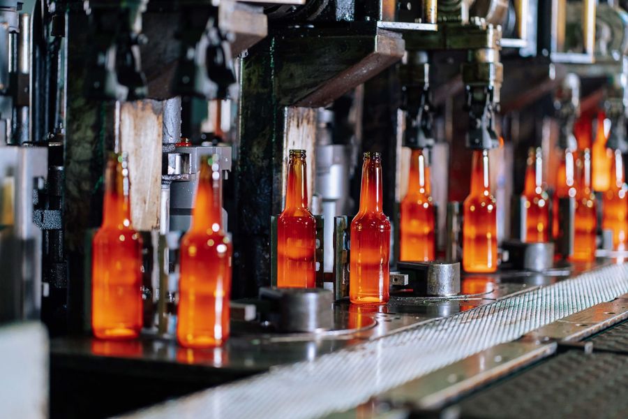 Glowing glass bottles on a production line