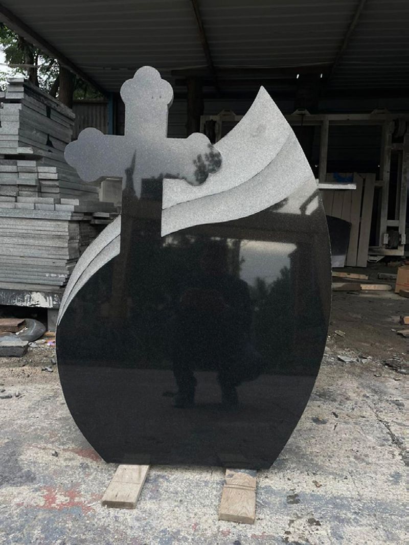 Polished black granite monument with a carved cross