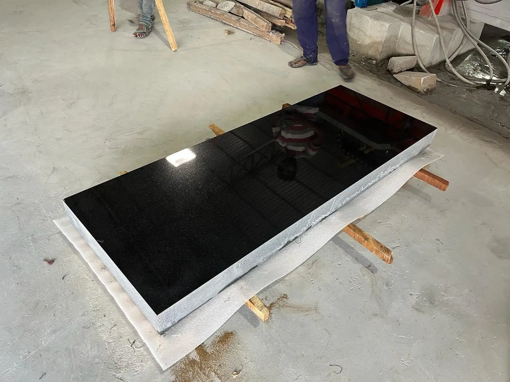 Polished black granite slab laid flat on timber supports
